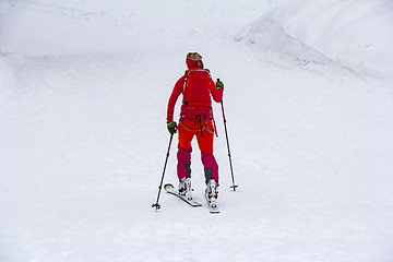 Image showing Woman with skis walk by snow on the mountain