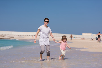 Image showing mother and daughter running on the beach