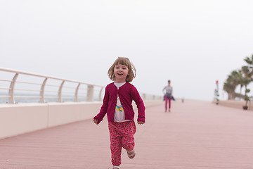 Image showing mother and cute little girl on the promenade by the sea