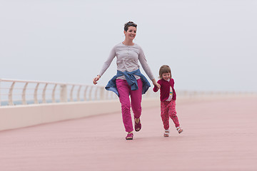 Image showing mother and cute little girl on the promenade by the sea