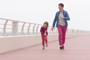 Image showing mother and cute little girl on the promenade by the sea