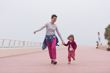 Image showing mother and cute little girl on the promenade by the sea