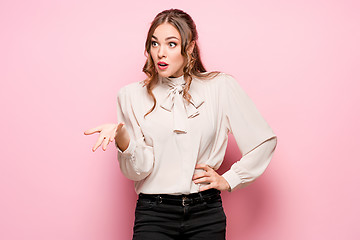 Image showing The serious frustrated young beautiful business woman on pink background