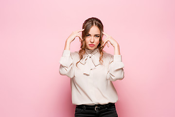 Image showing The serious frustrated young beautiful business woman on pink background