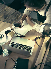 Image showing Portrait of a bearded businessman who is working with his notebook at loft studio.