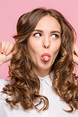 Image showing Close-up portrait of a woman doing a fish mouth expression, over a pink background