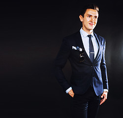 Image showing young pretty business man standing on black background, modern h