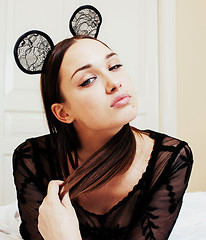 Image showing young pretty brunette woman wearing sexy lace mouse ears, laying