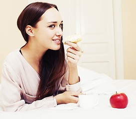 Image showing young pretty brunette woman laying in bed, luxury white interior