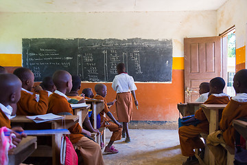 Image showing Children in uniforms in primary school classroom listetning to teacher in rural area near Arusha, Tanzania, Africa.