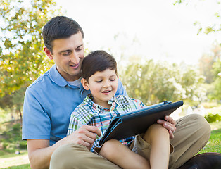 Image showing Happy Father and Son Playing on a Computer Tablet Outside.