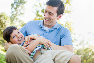 Image showing Loving Young Father Tickling Son in the Park.