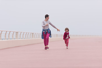 Image showing mother and cute little girl on the promenade by the sea