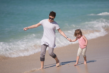 Image showing mother and daughter running on the beach