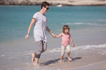 Image showing mother and daughter running on the beach