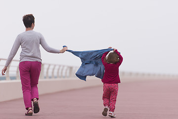 Image showing mother and cute little girl on the promenade by the sea
