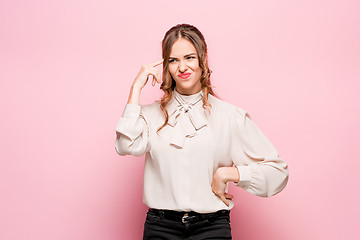 Image showing The serious frustrated young beautiful business woman on pink background