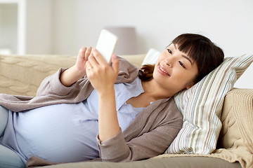 Image showing happy pregnant woman with smartphone at home