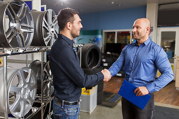 Image showing auto business owner and wheel rims at car service