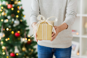 Image showing close up of man with christmas gift at home