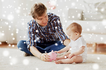 Image showing happy father with baby and piggy bank at home