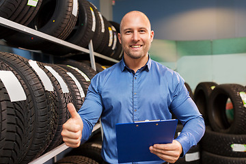 Image showing auto business owner and wheel tires at car service