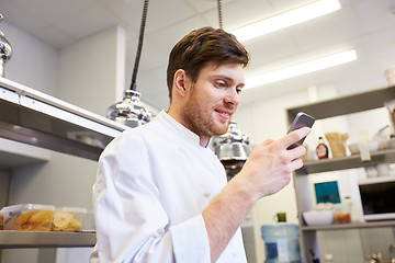 Image showing chef cook with smartphone at restaurant kitchen