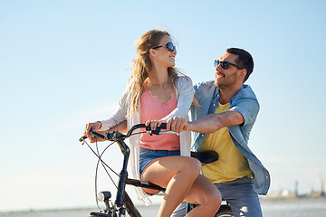 Image showing happy young couple riding bicycle at seaside