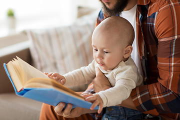 Image showing happy father and little baby boy with book at home