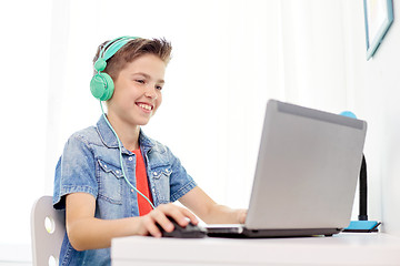 Image showing boy in headphones playing video game on laptop