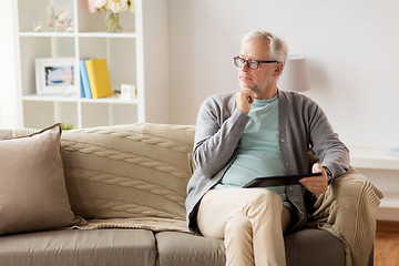 Image showing senior man with tablet pc sitting on sofa at home