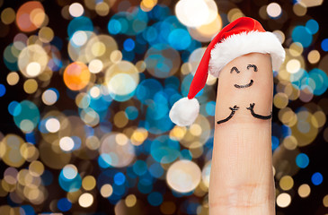 Image showing finger with smiley in santa hat at christmas