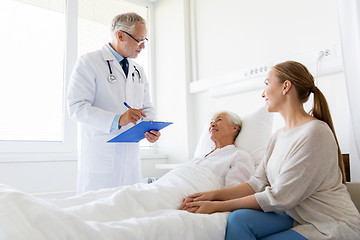 Image showing senior woman and doctor with clipboard at hospital