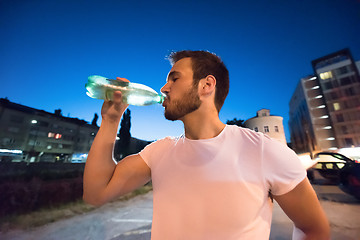 Image showing man drinking water after running session