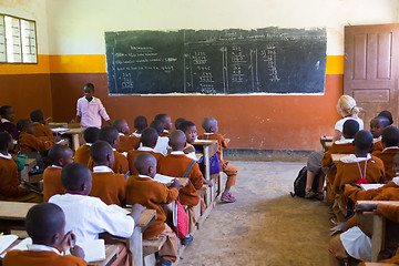 Image showing Children in uniforms in primary school classroom listetning to teacher in rural area near Arusha, Tanzania, Africa.