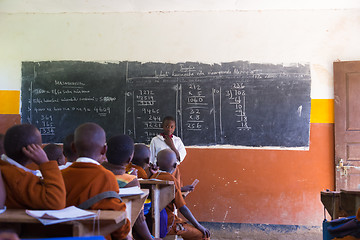 Image showing Children in uniforms in primary school classroom listetning to teacher in rural area near Arusha, Tanzania, Africa.