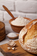 Image showing Homemade bread on old cutting board with a pile of fresh yeast