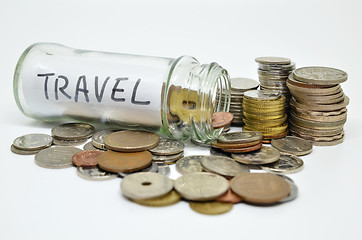 Image showing Travel lable in a glass jar with coins spilling out