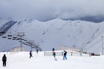 Image showing Blurred ski slope with skiers and snowboarders in evening not in