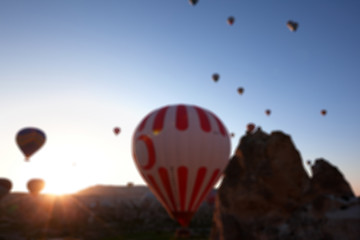 Image showing Blurred view on hot air balloons and blue clear sunlight sky and