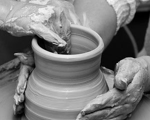 Image showing Two women in process of making clay vase on pottery wheel