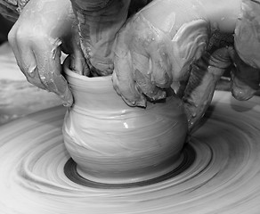 Image showing Beginner and teacher in process of making clay bowl on pottery w