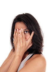 Image showing Young woman looking through her fingers.