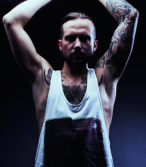 Image showing A man with tattooes on his arms. Silhouette of muscular body. ca