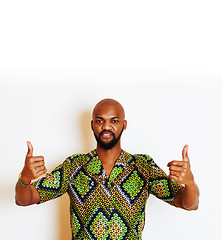 Image showing portrait of young handsome african man wearing bright green national costume smiling gesturing, entertainment stuff 