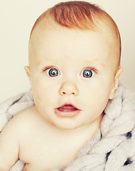 Image showing little cute red head baby in scarf all over him close up isolate