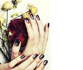 Image showing close up picture of manicure nails with dry flower red rose