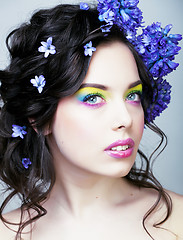 Image showing Beauty young woman with flowers and make up close up, real sprin