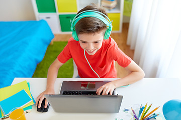 Image showing boy in headphones playing video game on laptop