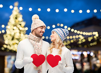 Image showing couple with red hearts over christmas tree lights